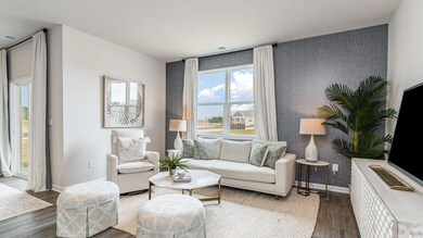 Living room featuring an accent wall, wood finished floors, baseboards, and wallpapered walls