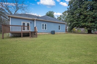 Rear view of property featuring a deck, central AC
