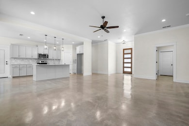 Unfurnished living room featuring finished concrete floors, ceiling fan, recessed lighting, and ornamental molding