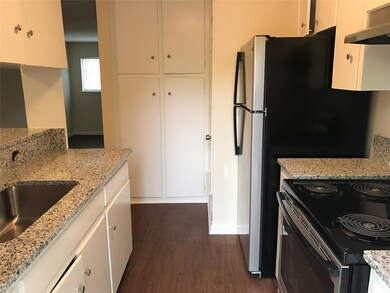 Kitchen with light stone counters, white cabinetr