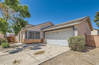 Ranch-style home featuring driveway, fence, a tile