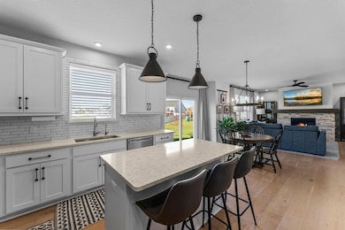 Crisp white cabinetry with under-cabinet lighting complements the center island with breakfast bar seating, while a closet pantry provides ample storage.