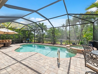 View of pool with glass enclosure, a patio area, a