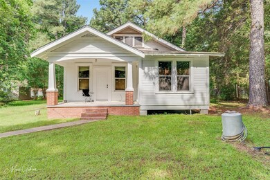 Bungalow-style home with a front lawn and covered 