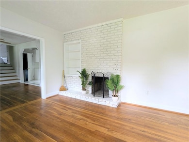 Unfurnished living room with a textured ceiling, stairway, wood finished floors, built in features, and a fireplace