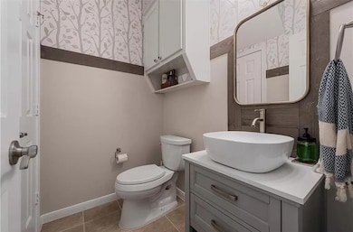 Half bath with vanity and light tile patterned floors