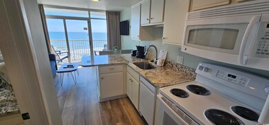Kitchen with white cabinets, white appliances, sin