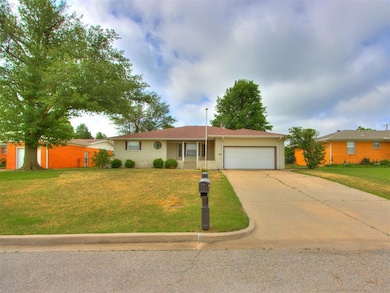 Ranch-style house featuring an attached garage, concrete driveway, a front yard, and brick siding