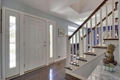 Gleaming dark walnut wood floors and grand stairca