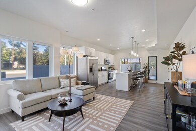 Living area with dark wood-type flooring, recessed lighting, and a chandelier