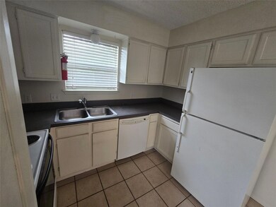 Kitchen with white appliances, dark countertops, 