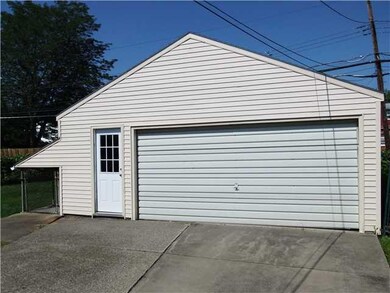 Exterior Back. Large garage, vinyl sided.