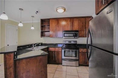 Kitchen with stainless steel appliances, dark countertops, a sink, light tile patterned floors, and open shelves