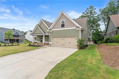Craftsman-style home featuring driveway, a front yard, and an attached garage