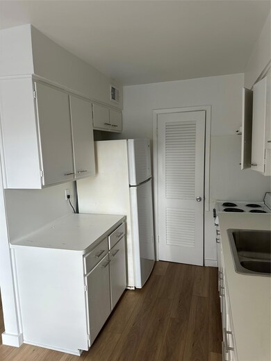 Kitchen featuring dark wood-style floors, light c