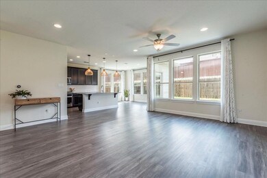 Unfurnished living room with dark wood-style floo