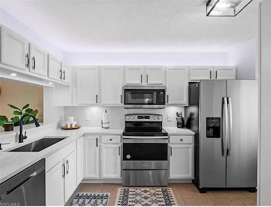 Kitchen featuring light countertops, light tile pa