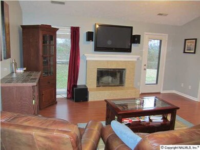 View of the family room from the foyer. Vaulted ceilings, laminate wood floor and fireplace gives this room an open and spacious feeling.