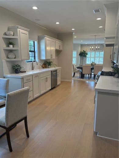 Kitchen with stainless steel dishwasher, light woo