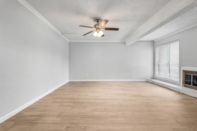 Unfurnished living room featuring a textured ceili