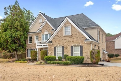 View of front of home featuring brick siding and a balcony