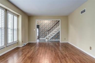 Spare room featuring stairway and wood finished floors