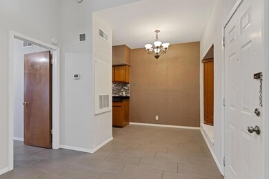 Kitchen with tasteful backsplash, a chandelier, b
