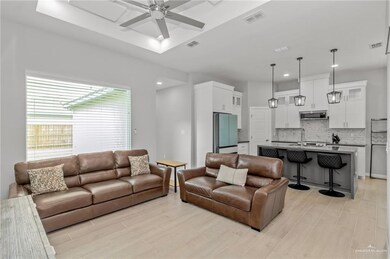 Living room with sink, ceiling fan, and light wood-type flooring