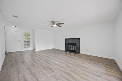 Unfurnished living room featuring ceiling fan, wo