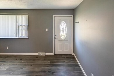 Foyer with a textured ceiling and dark hardwood / wood-style flooring