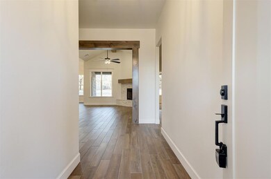 Corridor with wood-type flooring and vaulted ceili