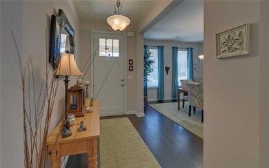Entrance foyer with dark wood-style flooring and baseboards