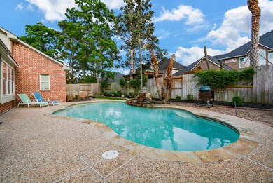 Backyard swimming pool with rock water fall and extended patio.