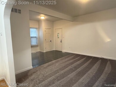 Foyer entrance featuring dark carpet, arched walkways, and dark tile patterned floors