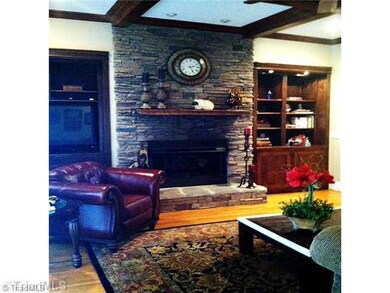 Den/Family/Great Room. This beautifully detailed den offers a stone fireplace, coffered ceilings, and a magnificent view of the lake through floor to ceiling windows and doors.