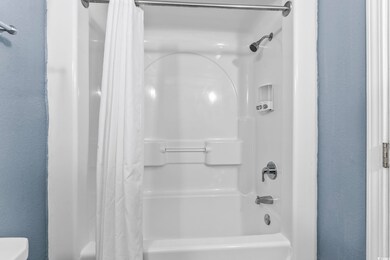 Bathroom featuring toilet and shower / bath combin