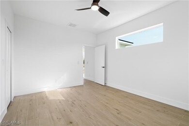 Unfurnished bedroom with ceiling fan and light har