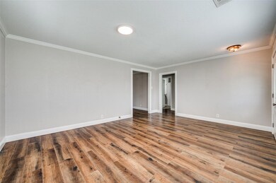 Spare room featuring baseboards, wood finished flo