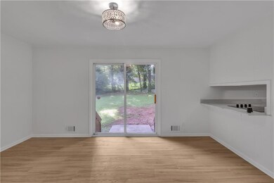 Unfurnished dining area featuring light wood-type flooring, baseboards, and a chandelier