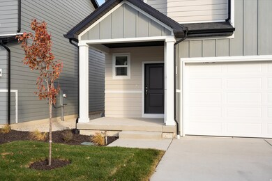 **DISCLAIMER - Exterior elevations may vary** Doorway to property featuring a garage, board and batten siding, a porch, and roof with shingles