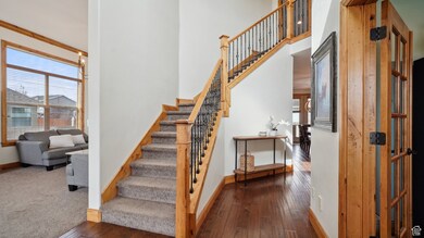 Stairway featuring baseboards, a healthy amount of sunlight, a towering ceiling, and hardwood / wood-style flooring