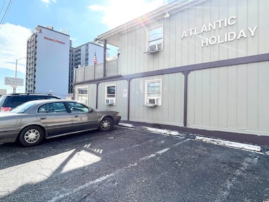 View of property featuring uncovered parking and cooling unit