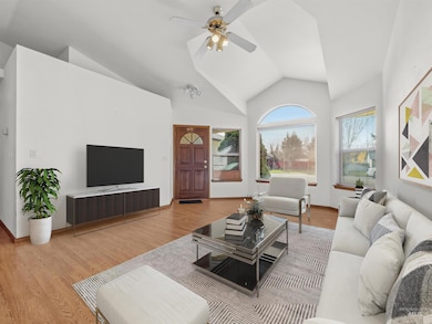 Living room with wood finished floors, ceiling fan, and high vaulted ceiling