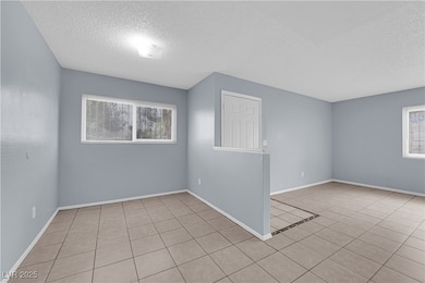 Spare room featuring baseboards, tile patterned fl