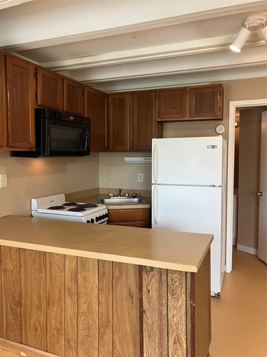 Kitchen with refrigerator, a sink, stove, a penin
