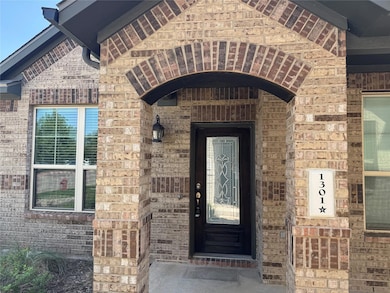 View of exterior entry featuring brick siding