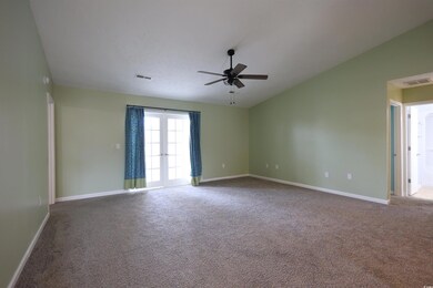 Carpeted spare room featuring a ceiling fan, visib