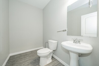 Half bath featuring baseboards and wood finished floors