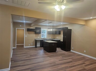 Kitchen with baseboards, a ceiling fan, a kitchen 
