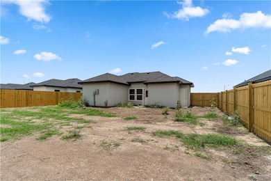 Back of property featuring a fenced backyard and stucco siding